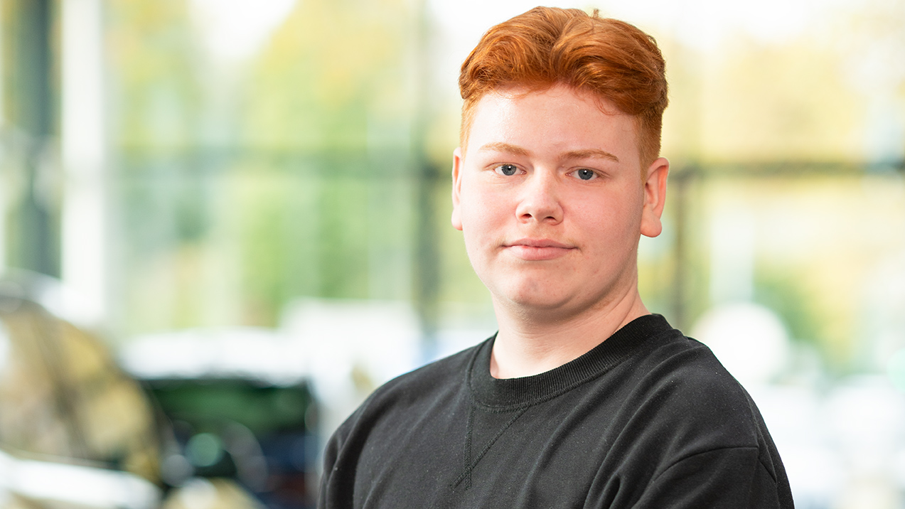 Mann mit roten Haaren in schwarzem Oberteil vor verschwommenem Hintergrund bei MINI Oberhausen.